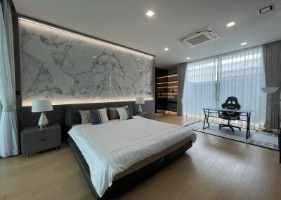 Spacious modern bedroom with large bed and artistic wall panel