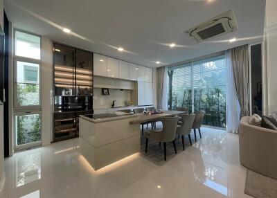 Modern kitchen with dining area, glossy floor tiles, and ample natural light