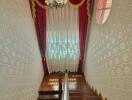 Elegant staircase with red curtains and ornamental lighting