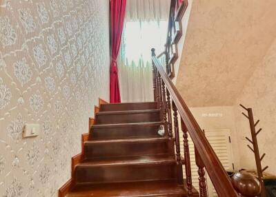 Elegant staircase with red curtains and detailed wallpaper