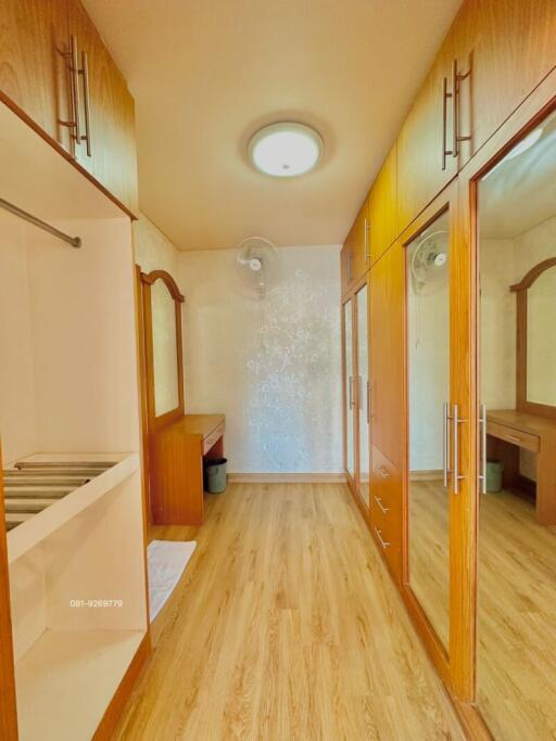 Bright corridor interior with wooden flooring and built-in wardrobes