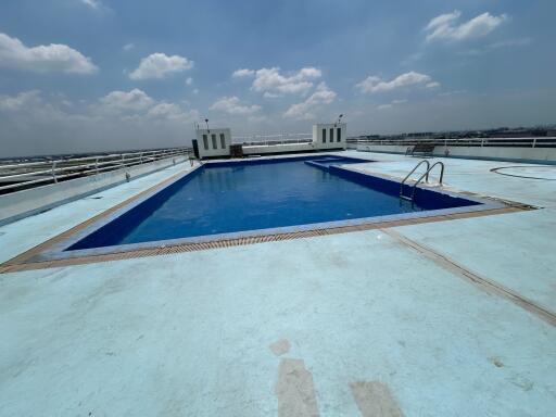 Rooftop swimming pool with city skyline view under a clear sky