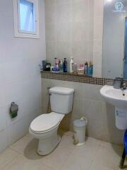 Compact bathroom with essential fixtures and tiled walls