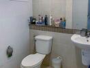 Compact bathroom with essential fixtures and tiled walls