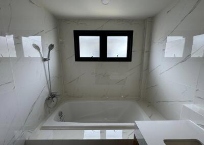 Modern bathroom with marble walls and a large bathtub