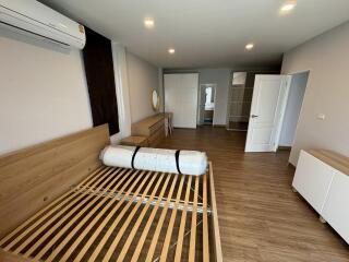 Spacious unfurnished bedroom with wooden flooring and air conditioning