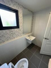 Modern bathroom with neutral color scheme, including toilet and bidet