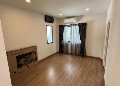 Spacious and well-lit living room with hardwood flooring and air conditioning
