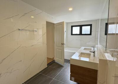 Modern bathroom with marble tiles and wooden cabinet
