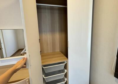Open wardrobe with shelves in a compact bedroom