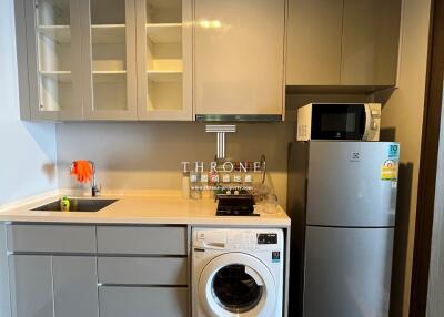 Modern compact kitchen with appliances and white cabinetry