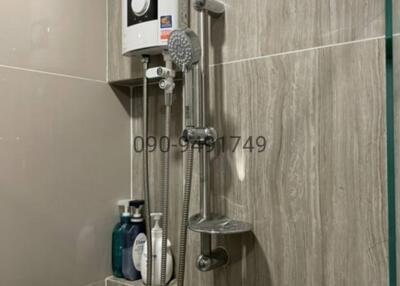 Modern wall-mounted gas water heater and shower system in a tiled bathroom