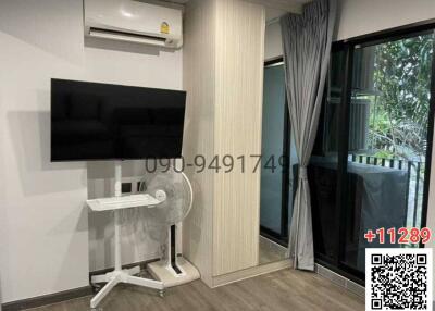 Compact bedroom with a wall-mounted TV and sliding glass door