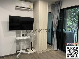 Compact bedroom with a wall-mounted TV and sliding glass door