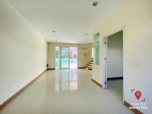 Spacious and Bright Living Room with Tile Flooring and Easy Access to the Stairs