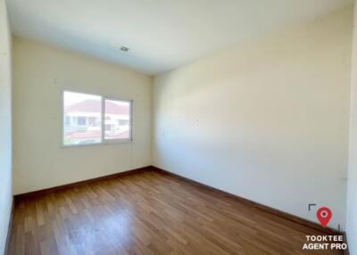 Empty bedroom with wooden floor and a large window