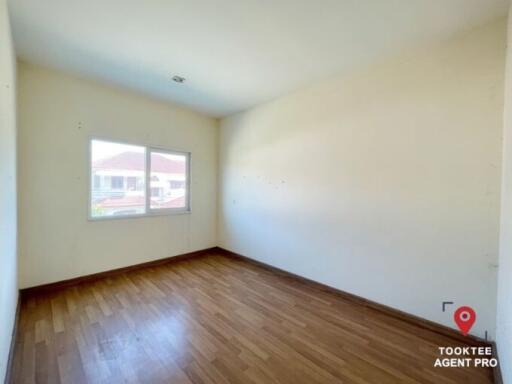 Empty bedroom with wooden floor and a large window