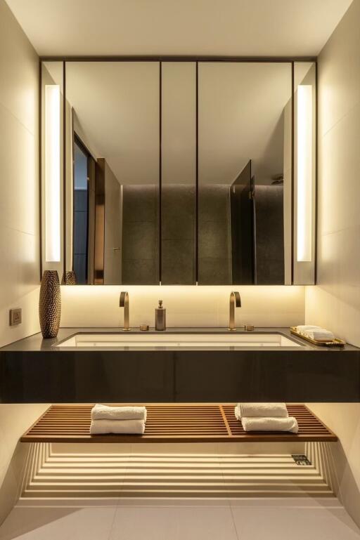 Modern bathroom with large mirror and warm lighting