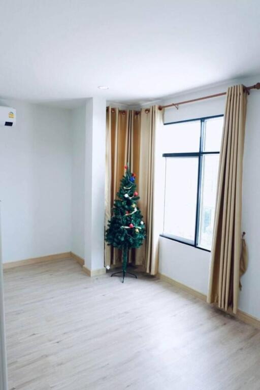 Spacious and bright living room with a Christmas tree by the window