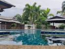 Elegant outdoor swimming pool surrounded by tropical vegetation and stylish residences