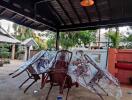 Covered patio area with outdoor dining furniture wrapped in plastic