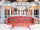 Spacious and brightly lit indoor atrium with traditional red bench and elegant architecture