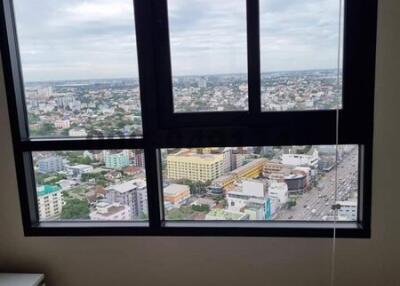 High-rise room with expansive window overlooking the city