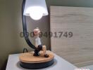 Stylish bedside lamp on a nightstand with decorative figurine