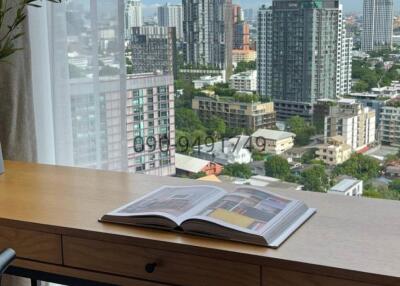 City view from high-rise apartment with desk and book