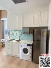 Compact modern kitchen with white cabinetry, stainless steel appliances, and washing machine