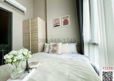 Modern bedroom with a comfortable bed, artwork on the wall and large window