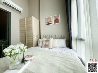 Modern bedroom with a comfortable bed, artwork on the wall and large window
