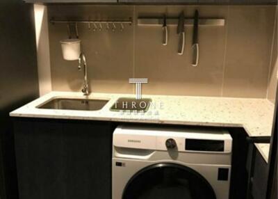 Compact modern kitchen with built-in appliances and washer