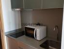 Compact modern kitchen with stainless steel sink and essential appliances