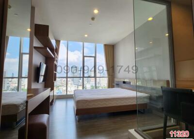 Contemporary bedroom with large windows and city view