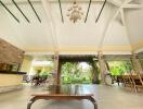 Spacious covered patio with elegant ceiling design, natural stone walls, and garden view