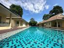 Bright and inviting outdoor swimming pool with surrounding residential buildings under a clear blue sky