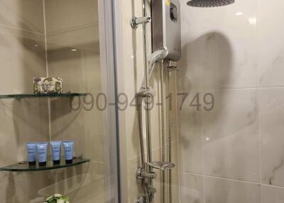 Modern bathroom with glass shower enclosure and marble tiles