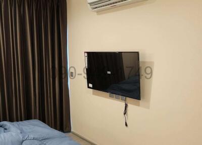 Cozy bedroom with modern air conditioning unit and wall-mounted TV