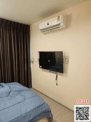 Cozy bedroom with modern air conditioning unit and wall-mounted TV