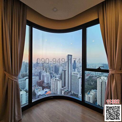 Spacious living room with large panoramic windows overlooking the city skyline