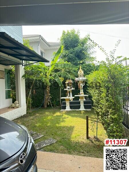 Outdoor view of a house with a garden and a spirit house