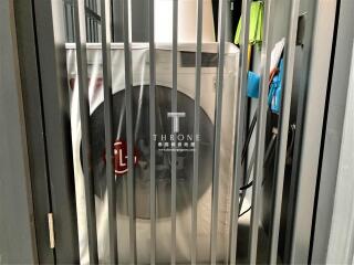 View through security bars of an enclosed space with a bike and cleaning equipment