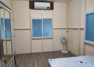 Compact bedroom with air conditioning and wooden flooring