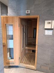Modern sauna room with wooden benches and glass door