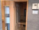 Modern sauna room with wooden benches and glass door