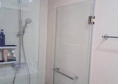 Modern bathroom with glass shower enclosure and wall-mounted shower head