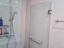 Modern bathroom with glass shower enclosure and wall-mounted shower head