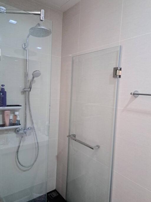 Modern bathroom with glass shower enclosure and wall-mounted shower head
