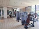 Modern gym with exercise equipment and large windows